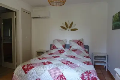 a bedroom with a bed with a red and white quilt at The Blue Tit - private swimming pool in LʼIsle-sur-la-Sorgue