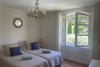 two beds in a room with a window at Propriété d'exception au coeur du Luberon in Robion en Luberon