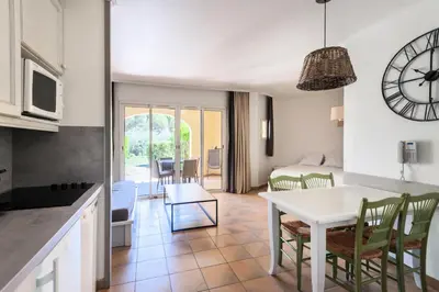 a kitchen and living room with a table and a clock at Village Pont Royal en Provence - maeva Home - Studio 5 personnes - Sélection MAE-2824 in Mallemort