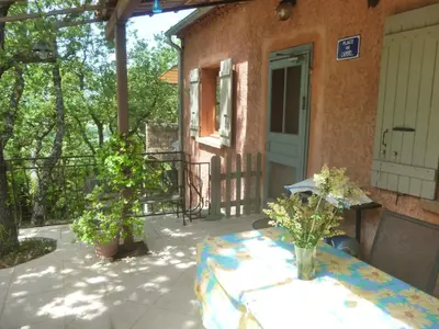 a patio with a table and a house at PROVENCE SOLEIL LUBERON PISCINE in Apt