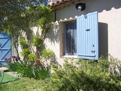 a window with a blue shutter on the side of a house at OUSTAOU DU GAYET gîte de charme avec piscine privée in Lourmarin