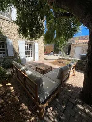 a bench sitting under a tree in a yard at La Maison de la Forge in Gordes