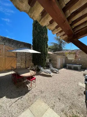 a patio with a table and chairs and an umbrella at La Maison de la Forge in Gordes