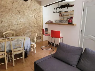 a living room with a couch and a table and chairs at La Maison de la Forge in Gordes