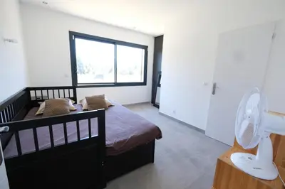 a bedroom with a bed with a fan and a window at LS6-408 ERNO Villa contemporaine avec piscine privée 8 couchages à Chateauneuf de Gadagne - Proche d’Avignon in Châteauneuf-de-Gadagne