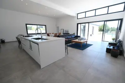 a kitchen and living room with a white counter top at LS6-408 ERNO Villa contemporaine avec piscine privée 8 couchages à Chateauneuf de Gadagne - Proche d’Avignon in Châteauneuf-de-Gadagne