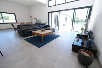 a living room with a couch and a table at LS6-408 ERNO Villa contemporaine avec piscine privée 8 couchages à Chateauneuf de Gadagne - Proche d’Avignon in Châteauneuf-de-Gadagne