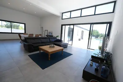 a living room with a couch and a table at LS6-408 ERNO Villa contemporaine avec piscine privée 8 couchages à Chateauneuf de Gadagne - Proche d’Avignon in Châteauneuf-de-Gadagne