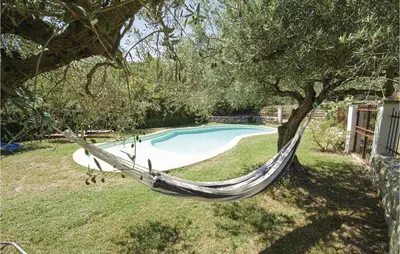 a hammock in a yard next to a swimming pool at Amazing Home In Caumont Sur Durance in Caumont-sur-Durance
