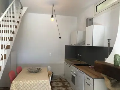 a small kitchen with a table and a staircase at La Tour- Pigeonnier Provençal - Mas des Sous Bois in Ventabren