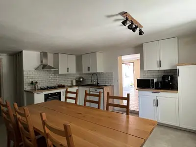 a kitchen with a wooden table and a dining room at Maison Provençale avec piscine in Carpentras