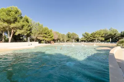 a swimming pool with people in the water at Village Pont Royal en Provence - maeva Home - Appartement 2 Pièces 7 Personnes Confort MAE-2253 in Mallemort