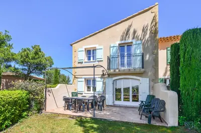 a house with a table and chairs in the yard at Les Maisons de Pont Royal en Provence - maeva Home - Maison climatisée pour 8 Personnes avec jardin privatif et terrasse MAE-2283 in Mallemort