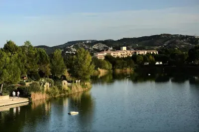 a body of water with buildings in the background at Les Coteaux de Pont Royal en Provence - maeva Home - Appartement 2 Pièces 4 Personnes - Confort MAE-5993 in Mallemort