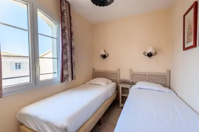 two beds in a room with a window at Les Coteaux de Pont Royal en Provence - maeva Home - Appartement 3 Pièces 6 Personnes - Sélection MAE-6001 in Mallemort