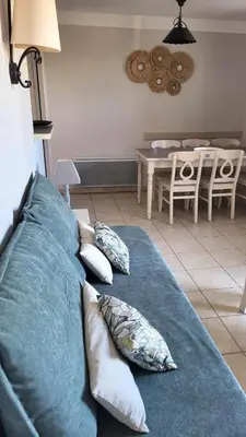 a blue couch with pillows in a living room at Les Coteaux de Pont Royal en Provence - maeva Home - Maison 4 Pièces 8 Personnes - Sélection MAE-6014 in Mallemort