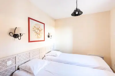 two beds in a room with white walls at Les Coteaux de Pont Royal en Provence - maeva Home - Appartement 2 Pièces 4 Personnes - Sélection MAE-6016 in Mallemort