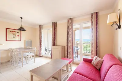 a living room with a red couch and a table at Les Coteaux de Pont Royal en Provence - maeva Home - Appartement 2 Pièces 4 Personnes - Sélection MAE-6017 in Mallemort