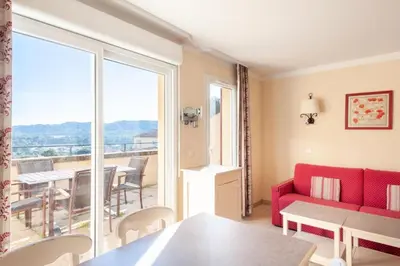 a living room with a red couch and a balcony at Les Coteaux de Pont Royal en Provence - maeva Home - Appartement climatisé 2 Pièces 4 Personnes - Sélection MAE-6022 in Mallemort