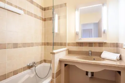 a bathroom with a sink and a tub and a mirror at Les Coteaux de Pont Royal en Provence - maeva Home - Appartement climatisé 2 Pièces 4 Personnes - Sélection MAE-6022 in Mallemort