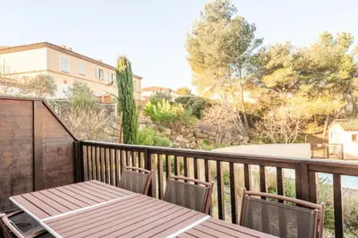 a wooden deck with a table and chairs on a balcony at Les Coteaux de Pont Royal en Provence - maeva Home - Maison 4 Pièces 8 Personnes - Sélection MAE-6026 in Mallemort