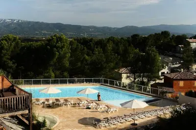 a large swimming pool with chairs and umbrellas at Les Coteaux de Pont Royal en Provence - maeva Home - Appartement 2 Pièces 6 Personnes - Sélection MAE-8180 in Mallemort