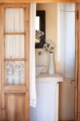 a bathroom with a sink and a vase of flowers on a counter at Le Clos d'Estellan - Piscine chauffée in Bonnieux