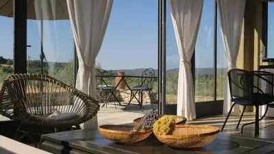 a table with baskets and chairs on a balcony at Le Clos d'Estellan - Piscine chauffée in Bonnieux