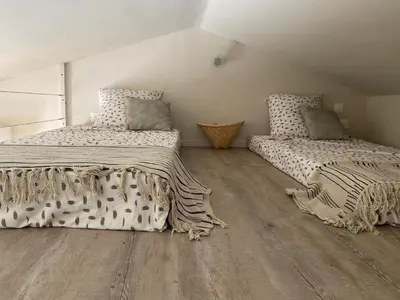two beds in a room with wooden floors at Instant Parfait en Provence Chambre privée et piscine in Monteux