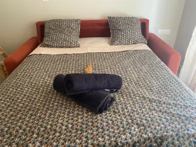 a bed with a black pillow on top of it at Instant Parfait en Provence Chambre privée et piscine in Monteux
