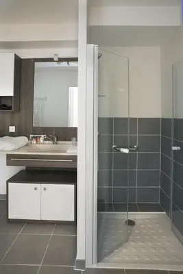 a bathroom with a glass shower and a sink at Domitys Les Cigales du Lubéron in Cavaillon