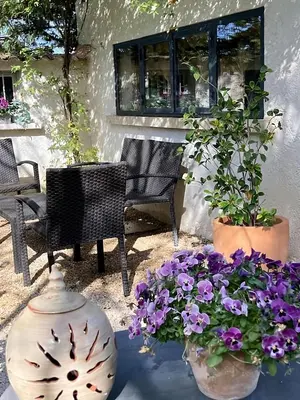 a table with two vases and flowers on a patio at Les cabanons de l'Oliveraie in Pernes-les-Fontaines