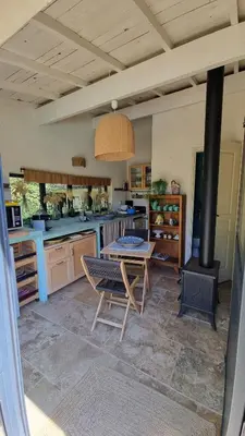 a large kitchen with a table and a stove at Les cabanons de l'Oliveraie in Pernes-les-Fontaines