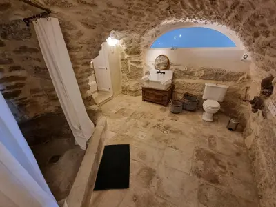 a stone bathroom with a toilet and a window at Maison au centre du village de Gordes avec vue incroyable in Gordes