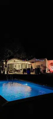 a swimming pool in front of a house at night at La Colinière, Chambre d'hôtes in Aix-en-Provence