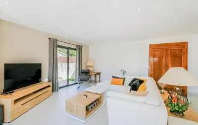a living room with a white couch and a tv at Amazing Home In Robion in Robion en Luberon