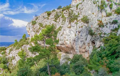 a rocky mountain with trees on top of it at Amazing Home In Robion in Robion en Luberon