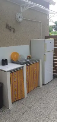 a kitchen with a counter and a refrigerator at Location saisonnière avec piscine et terrasse au pied du luberon in Lauris