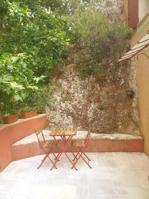 two chairs and a table on a patio at maison au coeur de Fontaine de Vaucluse, nichée sur le rocher et surplombant la sorgue in Fontaine-de-Vaucluse