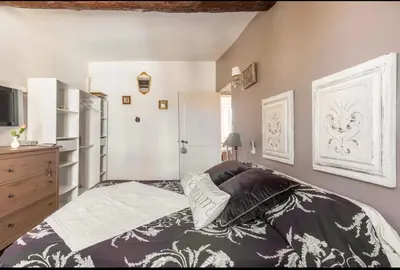 a bedroom with a king sized bed and a dresser at Douceur sur la Sorgue in LʼIsle-sur-la-Sorgue