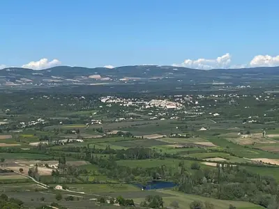 an aerial view of a green field with trees and houses at Maison LINA in Sault-de-Vaucluse
