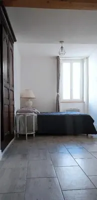a bedroom with a large bed and a window at Maison LINA in Sault-de-Vaucluse