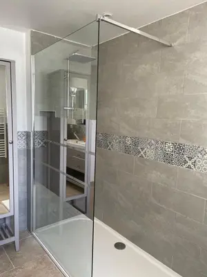 a shower with a glass door in a bathroom at Gîte l’Inattendu in Vachères