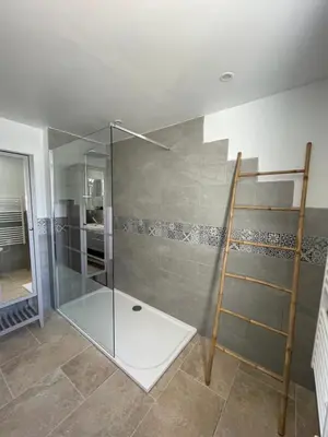 a shower with a glass door in a bathroom at Gîte l’Inattendu in Vachères