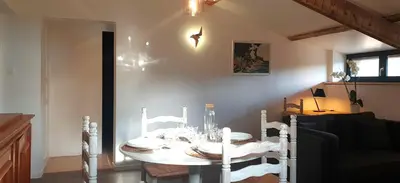 a dining room table with a white table and chairs at Logement calme avec vue sur le Luberon in Saignon
