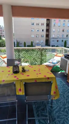 a yellow table with flowers on it on a balcony at Appartement Port Royal in Aix-en-Provence