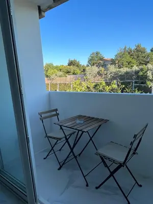 two chairs and a table on a balcony at Superbe appartement avec balcon et parking in Aix-en-Provence