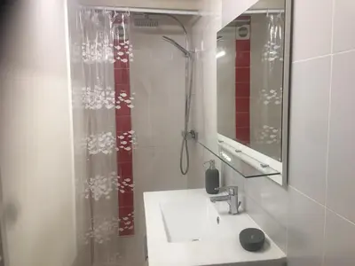 a bathroom with a sink and a shower with a mirror at 2 pièces et mezzanine dès 2 nuits in Vedène