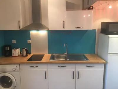 a kitchen with white cabinets and a sink and a refrigerator at 2 pièces et mezzanine dès 2 nuits in Vedène