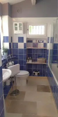 a blue tiled bathroom with a toilet and a sink at Bienvenue à la Source dans une Maison de Charme in Apt